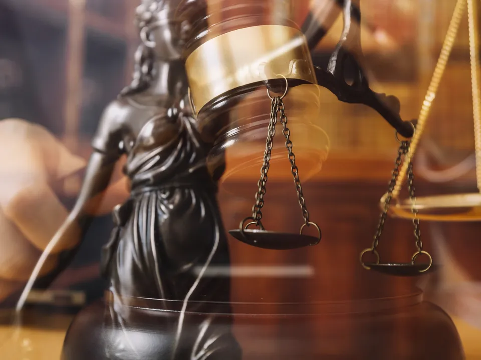 Lady Justice statue with scales and gavel in a courtroom